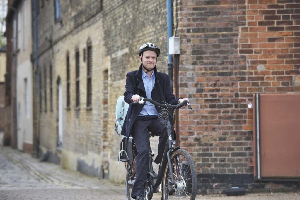 This is an image of a man cycling to work in King's Lynn