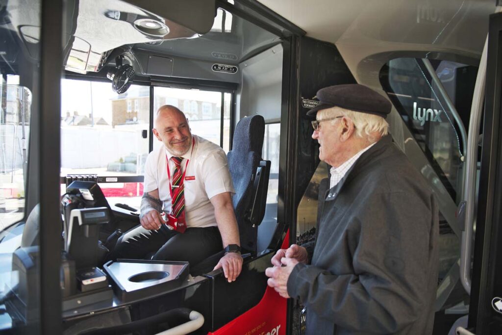 This is an image of a person boarding a bus in North Norfolk and chatting with the bus driver.