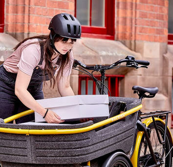 This is an image of a lady unloading a cargo bicycle