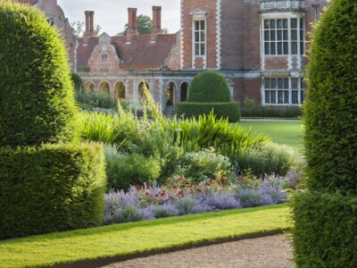 The garden with the house in the background at Blickling Estate, Norfolk. Blickling is a turreted red-brick Jacobean mansion, sitting within beautiful gardens and parkland.